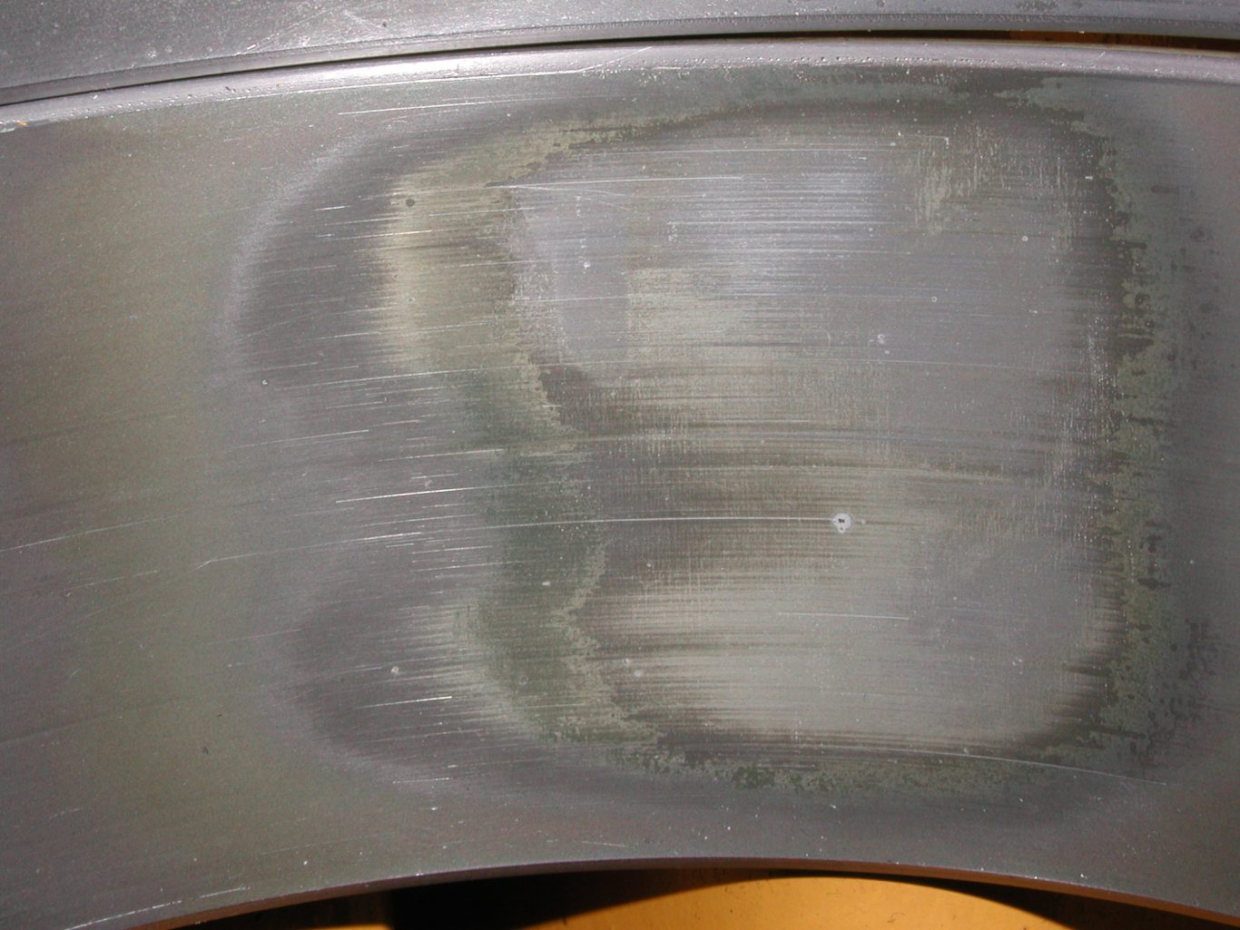 Light grey coloured metal surface with clearly defined areas of more polished appearance and then a further worn area for the loaded area