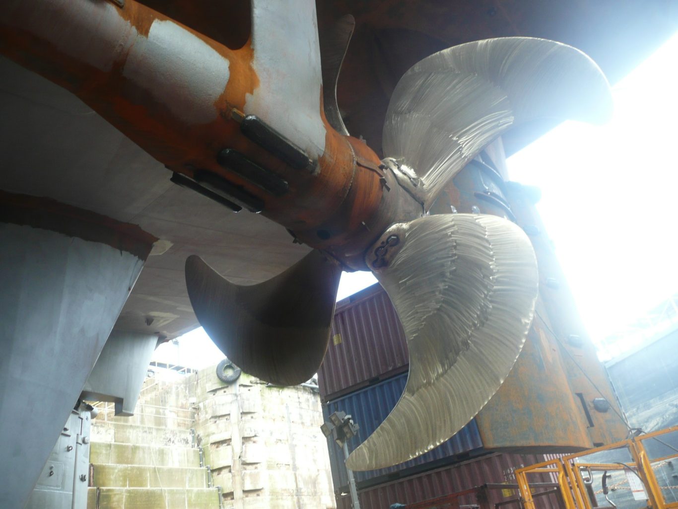 A four bladed propellor and the stern tube at the rear of a ferry ship in drydock
