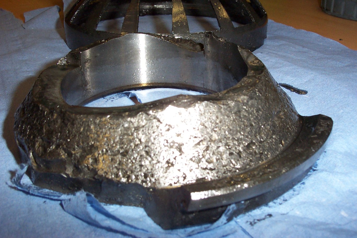 The inner race of a taper roller bearing with severe surface distress of the raceway and the outer lip broken