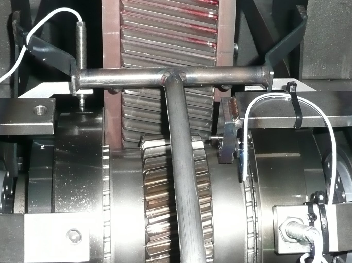 A large and small single helical gear mesh with an oil spray bar